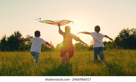 Children toy plane. Kite flies in hands of child in summer in park under sun. Children Boy, girl play with toy kite. Child's dream of flying concept, child runs across field at sunset with kite, sky Foto stock