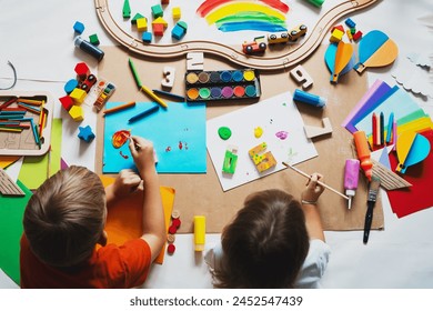 幼稚園や保育園で工芸品を描く子供たち。創造的な教育玩具や用品を持つ小さな子供たち。С就学前または保育中の子供の教育と開発。の写真素材
