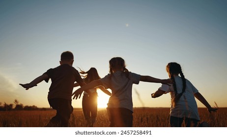Children running in park at sunset. happy family kindergarten kids dream concept. Kids running in grass silhouette. Children playing outdoors lifestyle silhouette. Kids playing in park at sunrise Foto stock