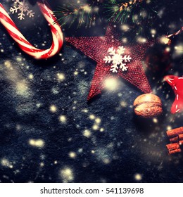 Christmas decorations on dark background, vintage retro style. Winter Xmas card with stars, bells, balls and candies.
 Stock Photo