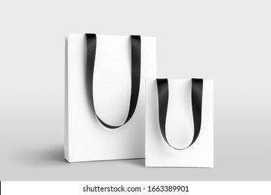 Composition of blank shopping bags mockup with ribbon hangers to place your design. Front view on white background. Fashion branding scene. Arkistovalokuva