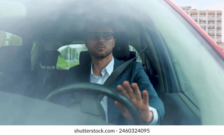 Confident attractive elegant man in business suit driving car in the city. Transport, business and people concept. Real time Stock-foto