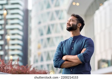 Confident rich eastern indian business man executive standing in modern big city looking and dreaming of future business success, thinking of new goals, business vision and leadership concept. Stock-foto