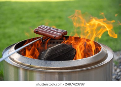 ステンレス鋼の無煙ファイヤーピットの上にホットドッグを調理するの写真素材