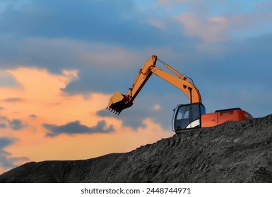 露天掘りの炭鉱。採掘ショベルは、採石場でトラックに石炭を積み込みます。掘削機は、オープンピット石炭鉱山で掘る。日没の背景にオープンピットの掘削機。opencastの重機。 の写真素材
