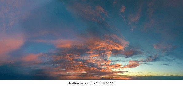 鮮やかなオレンジと黄色の雲の背景に夕日が広がるカラフルな夕焼け空の写真素材