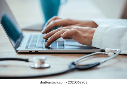 Close up of young female doctor hands working with her computer in medical consultation 库存照片