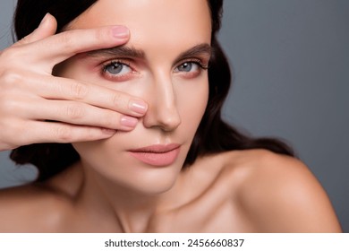 Photo en gros plan de femme doigts tactiles yeux, regard isolé sur fond gris : photo de stock