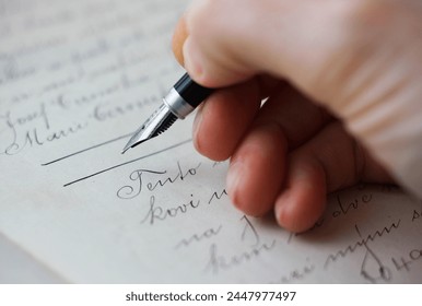 チェコ語で書かれた購入契約書にサインした万年筆を持つ白人の女性の手の接写。古い法律、法的問題、古い手書きの文書の概念。の写真素材