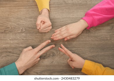 Closeup of people playing rock, paper and scissors on wooden background, top view Stock-foto