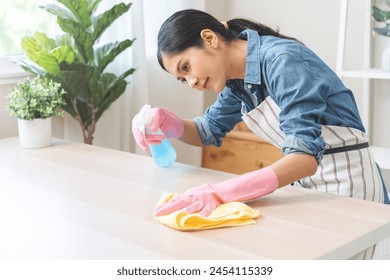 清潔さアジアの若い女性は、自宅のテーブルの上に雑用クリーニング作業、手袋を使用して手袋を着用スプレーボトルでほこりを除去します。家庭用衛生クリーンアップ、クリーナー、クリーニング用機器ツールの写真素材