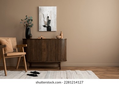 Creative composition of living room interior with mock up poster frame, copy space, wooden sideboard, vase with branch, rattan armchair, beige rug and personal accessories. Home decor. Template.  Stock-foto