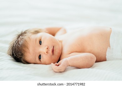 かわいい1週間の少年のポートレート。毛布に寝かしつつ、カメラを見ながら生まれ変わった女の子。の写真素材