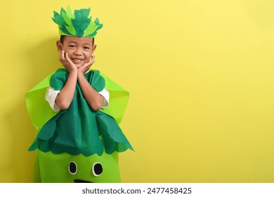 Cute child boy wearing vegetable costume isolated on yellow background. With copy space Foto stock