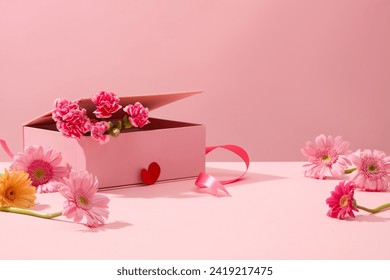 Cute pink background with gerberas and fresh carnations decorated. Sweet and romantic women's day decoration ideas. Empty space for product presentation, front view Stock Photo