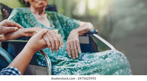 A Daughter's Love. Elderly asian woman on wheelchair at home with daughter take care. 库存照片