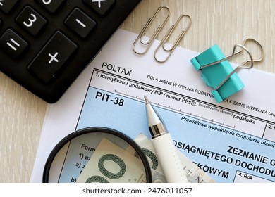 給与所得または損失発生額の申告、会計表のPIT-38税務フォーム、ペンとポーランドのズロティ紙幣の接写の写真素材