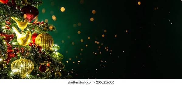 Decorated with ornaments and lights Christmas tree on dark green background. Merry Christmas and Happy Holidays greeting card, frame, banner. New Year. Noel. Winter holiday theme. 
 Stock Photo