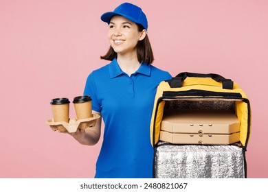 Delivery woman wear blue cap t-shirt uniform work as dealer courier hold pizza in paper blank craft flatbox, brown cup tea coffee to go, thermal bag isolated on plain pink background. Service concept 库存照片