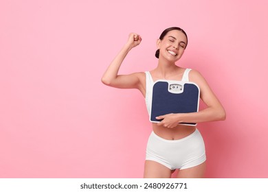 식단과 체중 감량 개념. 분홍색 배경에 바닥 스케일과 행복 한 젊은 여자. 텍스트 스페이스 스톡 사진