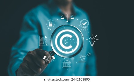 Digital copyright or patent concept. Author rights and patented intellectual property. Businessman holding a magnifying glass focuses on a copyright symbol surrounded by legal icons. trademark license 库存照片