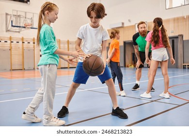 A diverse group of young children playing basketball with enthusiasm and energy in a vibrant setting. Foto stock