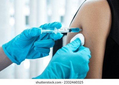 Doctor making a vaccination into patient with needle getting immune vaccine at arm for flu shot, coronavirus protective of epidemic. Arkistovalokuva