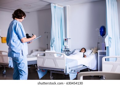 Doctor writing on clipboard in hospital Stockfoto