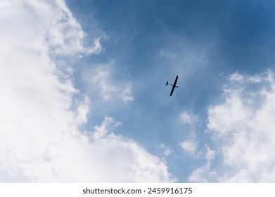 drone flying in the blue sky. Unmanned military drone flying in the sky above the clouds, technology. Concept: military reconnaissance drone, incident in the sky, war in Ukraine. Arkistovalokuva
