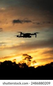 Drone silhouette at sunset fly Arkistovalokuva