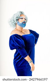 エレガントな青いドレスと青ひげを身に着けたドラッグクイーンは、ユニークでスタイリッシュな外観を示しています。あの女は堂々と堂々とした態度を取るの写真素材