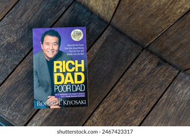 Dubai, UAE - May 27, 2024: Close-up of Robert Kiyosaki and Sharon Lechter's Rich Dad Poor Dad book on a wooden table.  – Ảnh báo chí có sẵn