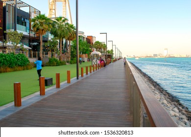 Dubai/UAE - October 17, 2019: Bluewaters island promenade during sunset. Wooden walkway along the island luxury buildings and bay.  에디토리얼 스톡 사진