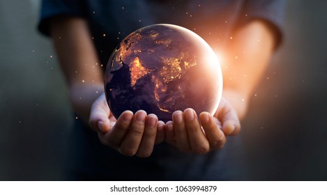Earth at night was holding in human hands. Earth day. Energy saving concept, Elements of this image furnished by NASA Stock Photo