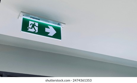 建物の緑の色と狭い出入り口への緊急出口標識方向。の写真素材