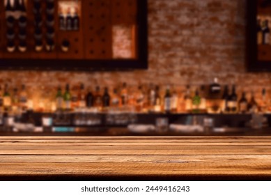 Empty wooden bar counter with defocused brick wall with liquor bottles, copy space for product placement  Stock-foto