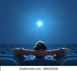Empty blue cinema with person sitting in center and looking on bright star on screen Foto stock
