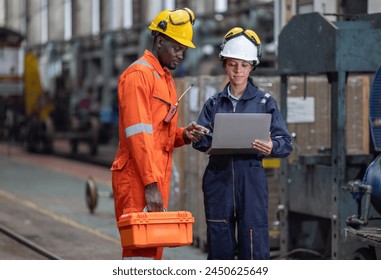 Engineering supervisor uses laptop to do diagnostics, enter data, check maintenance schedules, discuss work orders with a technician. Ensure that CO2 emissions are reduced in overall train operation.: stockfoto