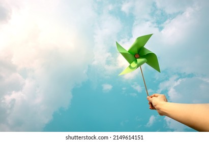ESG and Clean Energy Concept. Hand Raise up a Wind Turbine Paper into the Sky. Decrease Carbon and Produce a Green Power. World Earth Day, Sustainable Resources, Environmental Care Stock Photo
