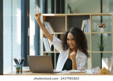 Excited happy African American woman feeling winner rejoicing online win got a new job opportunity, overjoyed motivated mixed race girl student receive good test results on her laptop. 库存照片