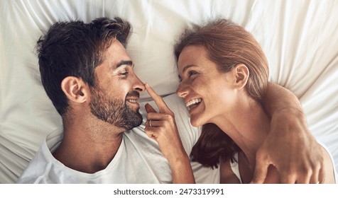 Face, nose and smile with couple in bed together from above for morning bonding, love or romance. Fun, happy or playful with man and woman in bedroom of home for anniversary, honeymoon or marriage Stockfoto