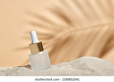 face serum of glass bottle with a pipette on a natural background with sand. Essential oil for moisturizing body skin. mockup of beauty fashion cosmetic bottle dropper product with skincare concept. ஸ்டாக் ஃபோட்டோ