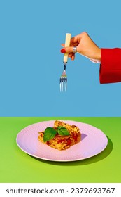 緑と青の背景に美味しいイタリア料理、ラザニアの上に女性の手を持つフォーク。ボローネズソースとバジル。イタリア料理、料理、味、料理、メニューのコンセプト。ポップアート。ポスター、広告の写真素材