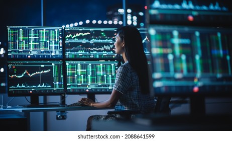 Financial Analyst Working on a Computer with Multi-Monitor Workstation with Real-Time Stocks, Commodities and Exchange Market Charts. Businesswoman at Work in Investment Broker Agency Office at Night. Foto stock