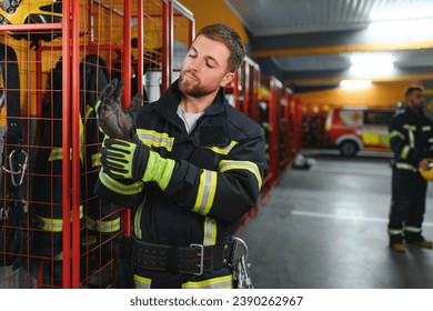 A firefighter puts on a fire uniform at the fire department. Foto Stock