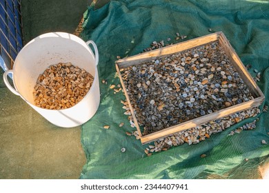 貝殻の選別に用いる釣用ネットと釣用バケツ付き木目メッシュの写真素材