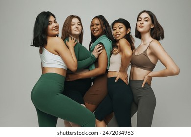 Five young, confident women of different ethnicities and body shapes posing in stylish athletic wear looking at camera with smile. Concept of beauty, support, unity, body positivity, diversity. Ad Stock-foto