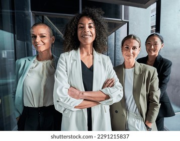 Four multiracial empowered women looking at camera confident and cheerfully at the office. Headed by a African American woman boss. 庫存照片