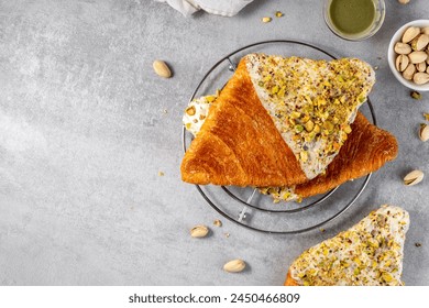 Flat Croissant, Trendy Pastry, Croissant with Pistachio Glaze and Crushed Nuts Foto stock
