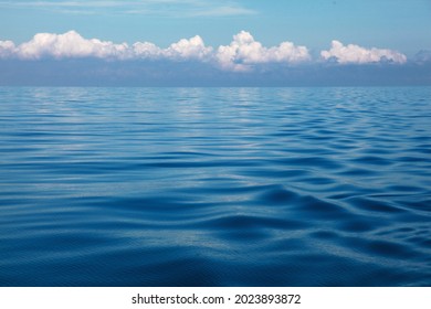 nubes blancas onduladas sobre mares azules vívidos Foto de stock